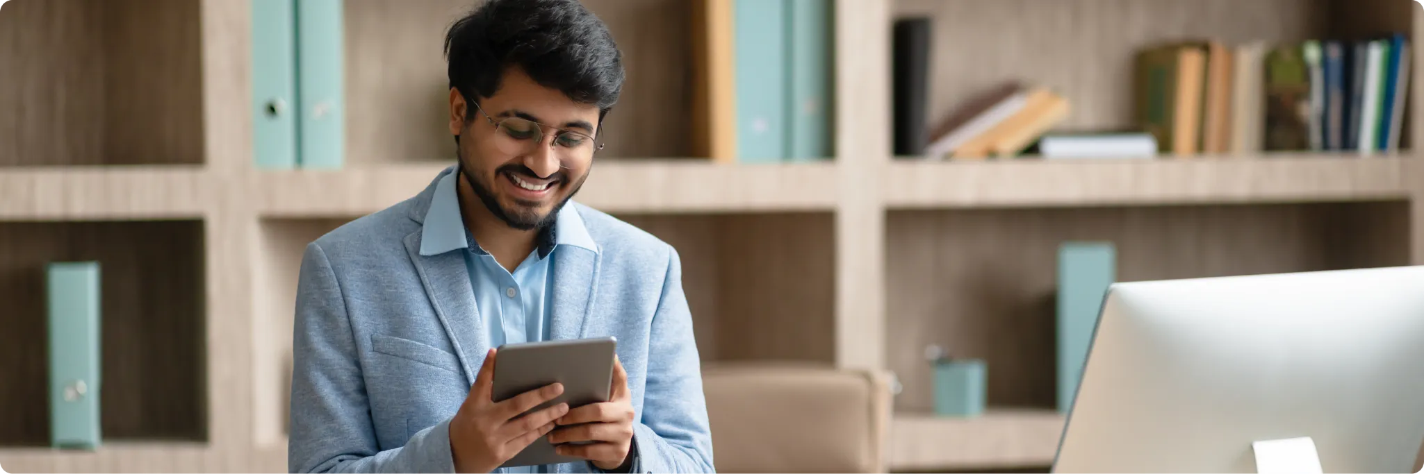 Professional financial advisor working on a tablet in an office.