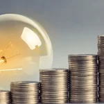A bulb and coins signifying investment ideas in India in 2026